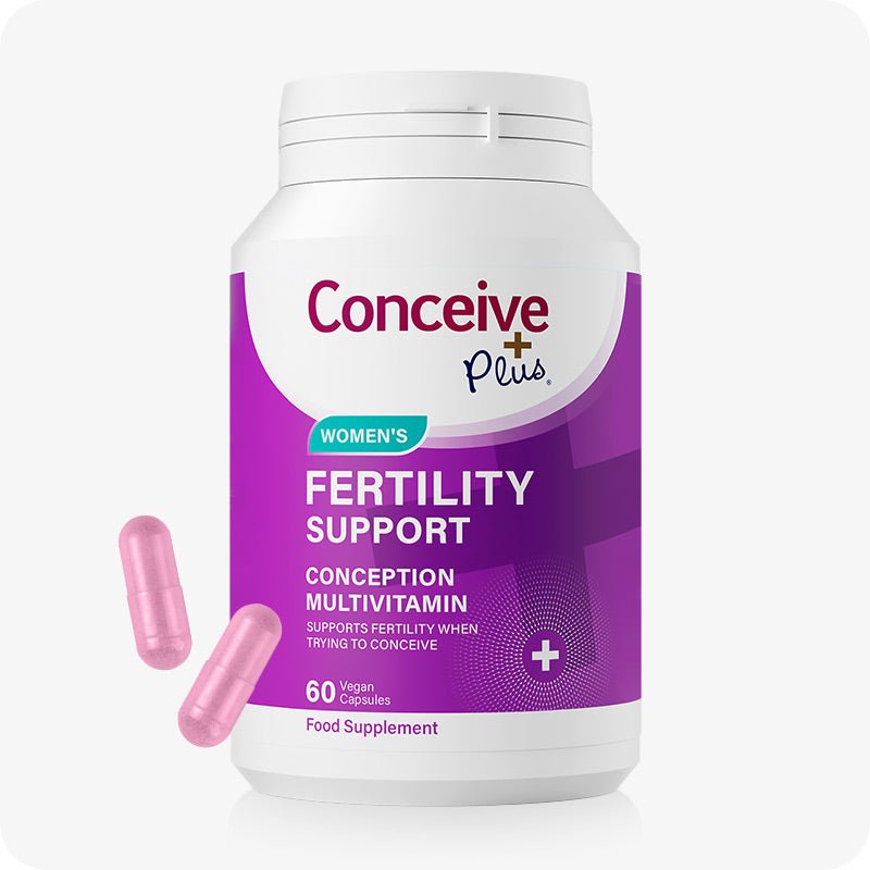 Conceive Plus Women's Fertility Support supplement bottle with 60 pink vegan capsules. The purple and white label emphasizes conception multivitamin benefits for women trying to conceive. Two pink capsules are shown beside the bottle.