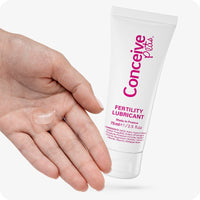 For Conceive Plus Fertility Lubricant Tube + Applicators bundle, the image shows the 75ml tube next to an open hand with a small amount of lubricant on the palm. The product appears with clean white packaging and pink branding, demonstrating texture and intended use on skin.