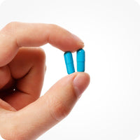 Conceive Plus Men's Fertility Support + Lubricant featuring blue capsules of Men's Fertility Support held between two fingers in a close-up image, displayed against a clean white background to emphasize supplement size, daily dosage, and ease of intake for male fertility support.